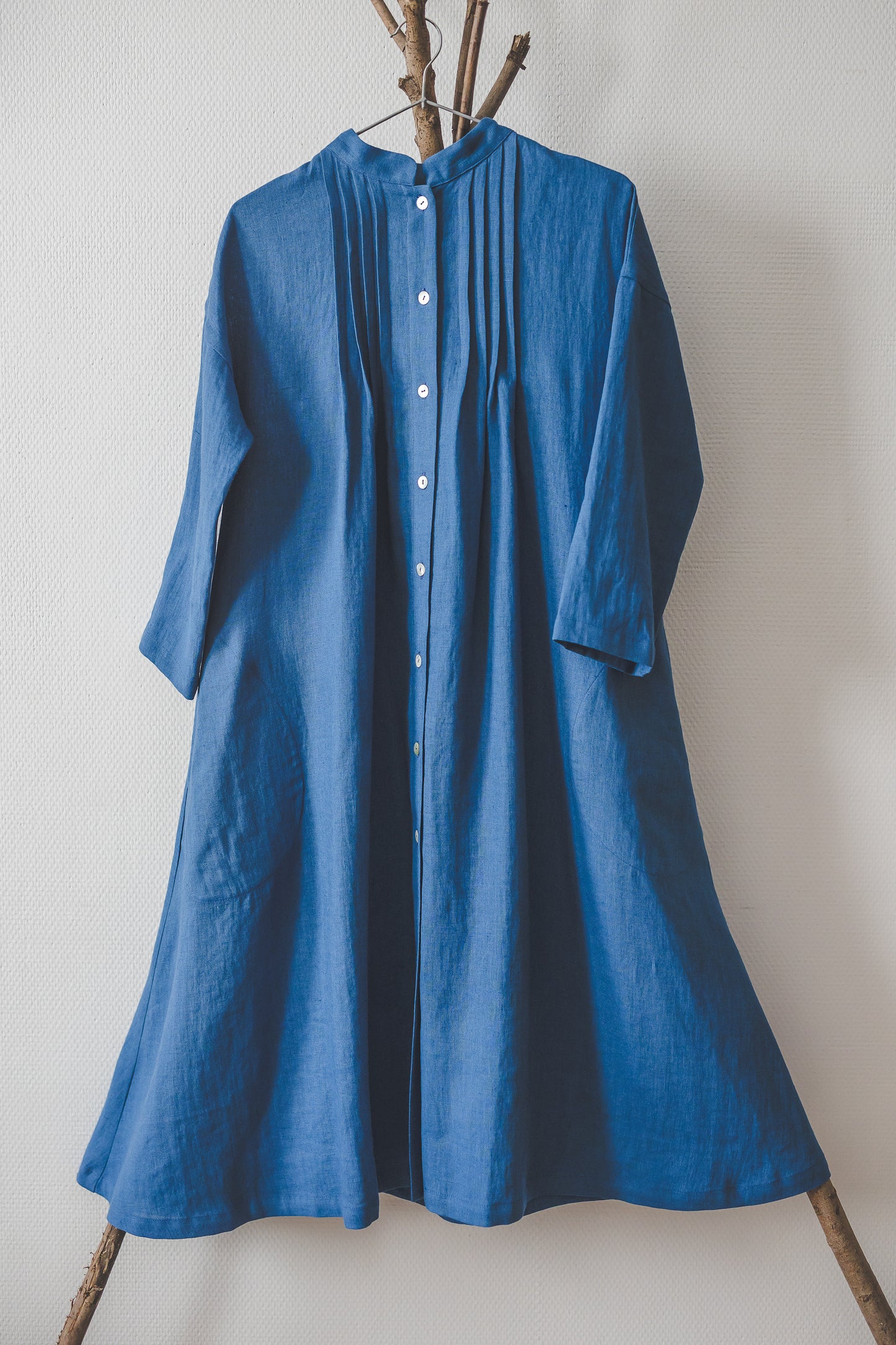 Blue color linen shirt dress hanging on a hanger