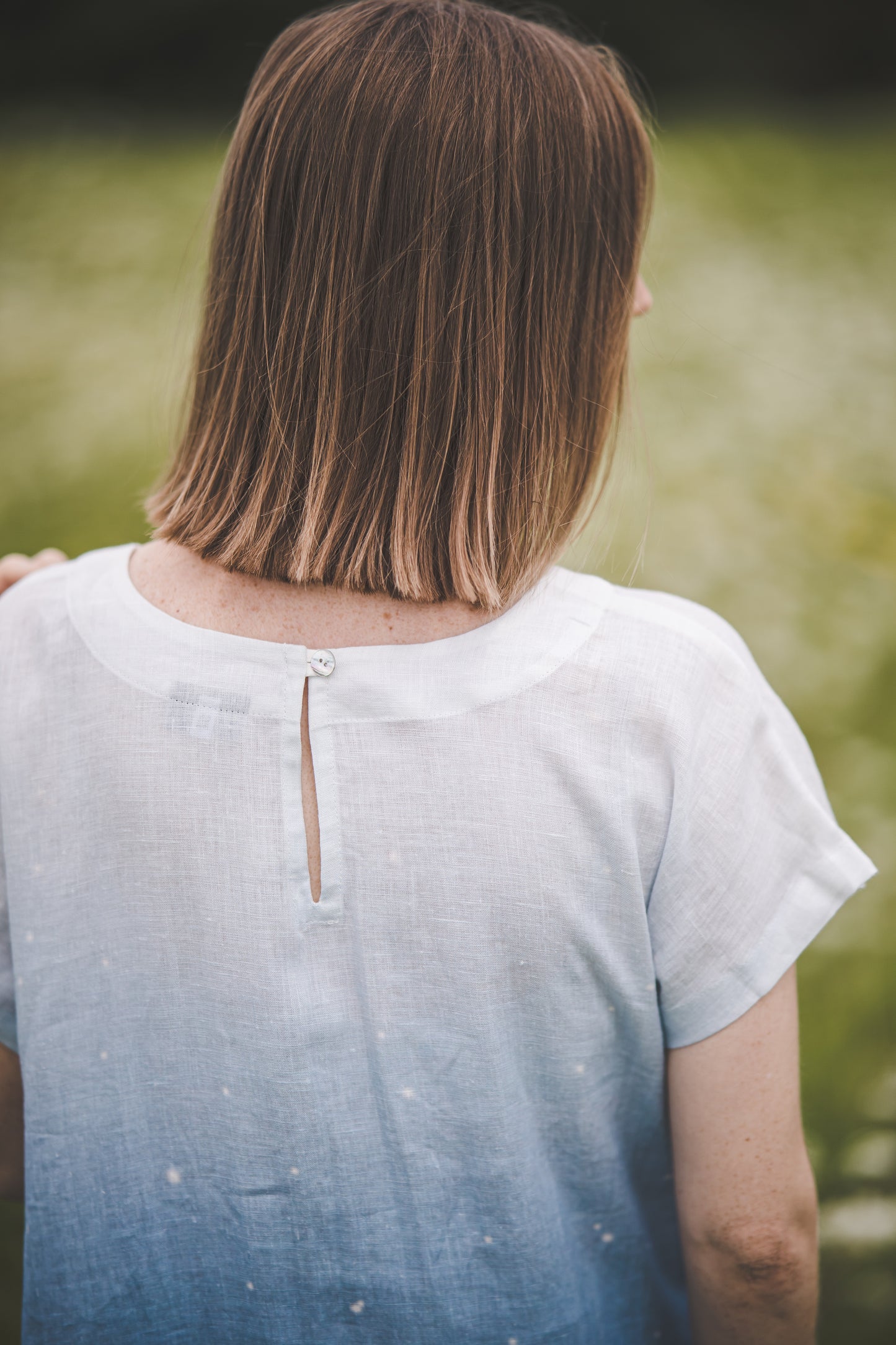 Shell button and a slit closure at neckline