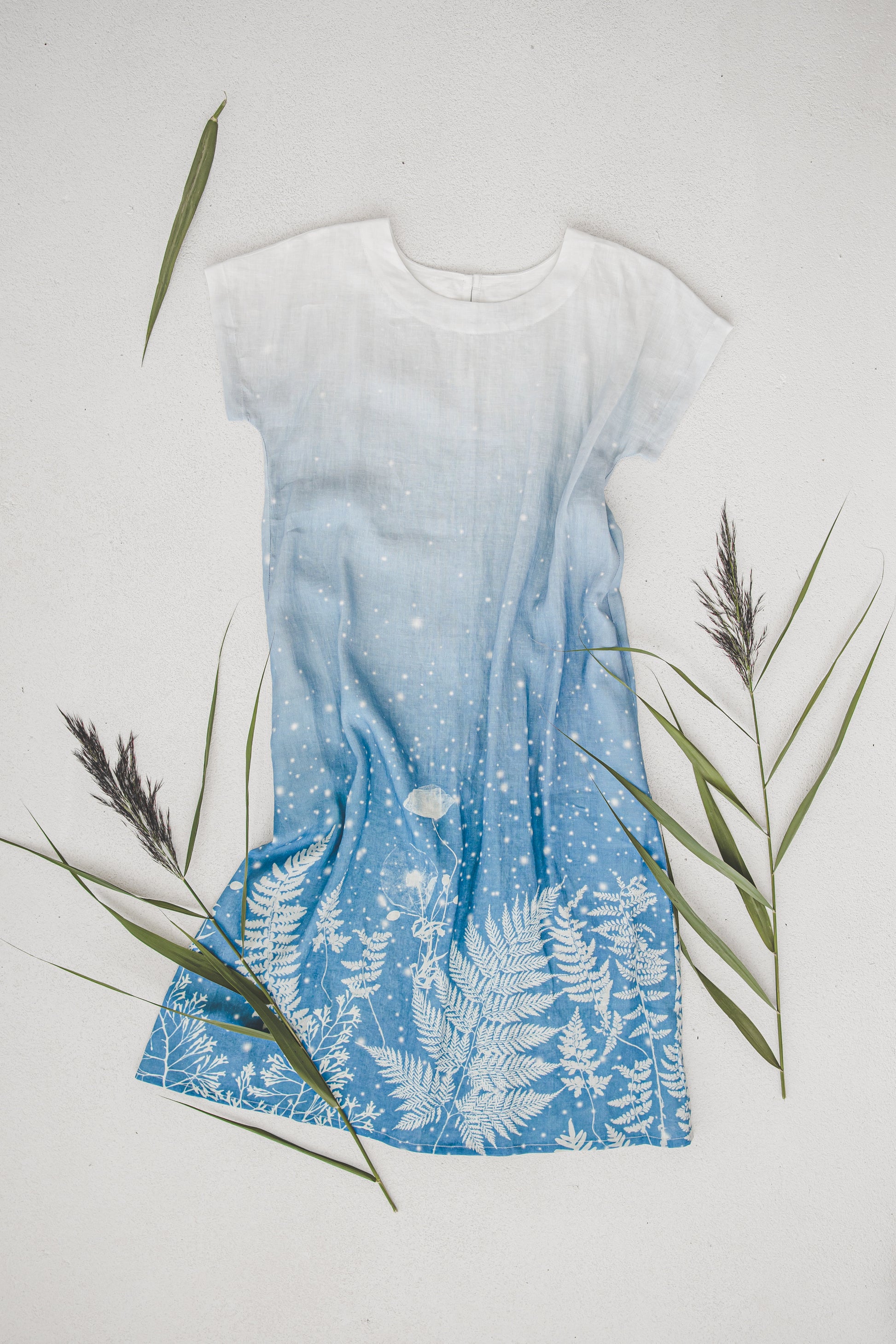 Mid-calf linen beach dress with white blue gradation, lying flat